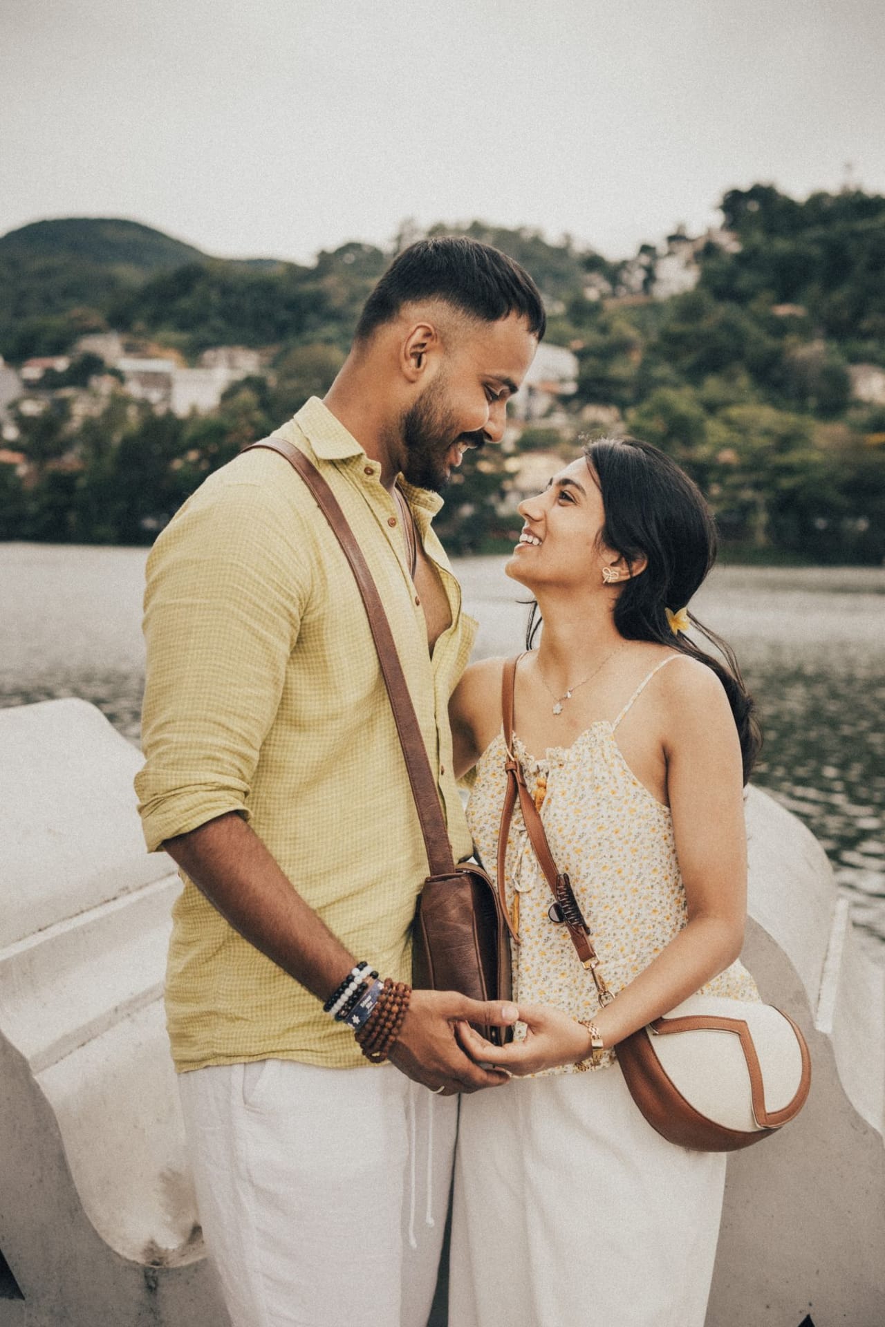 A couple holding hands and laughing on a white boat on Kandy Lake